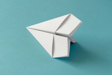 kağıt origami uçak mavi turkuaz kağıt arka plan üzerinde