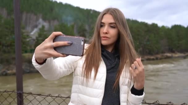 Das Mädchen Macht Ein Selfie Vor Der Kulisse Eines Gebirgsflusses — Stockvideo