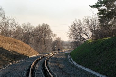 Bir çocuk demiryolunun ortasındaki mesafeye gidiyor..