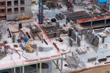 Üst kat manzarası. İnşaat alanında inşaat malzemeleri, tesisat ve beton duvarlar..