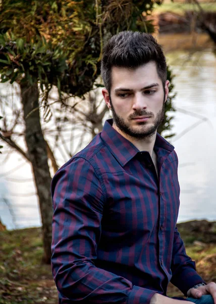 Rapaz parado sobre ponte contra o ceu azul