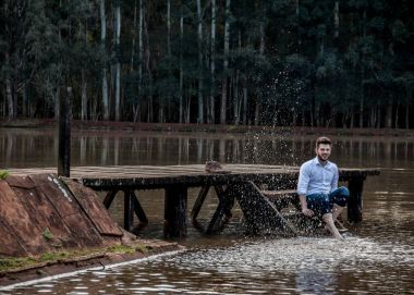 Rapaz de camisa branca se divertindo no lago