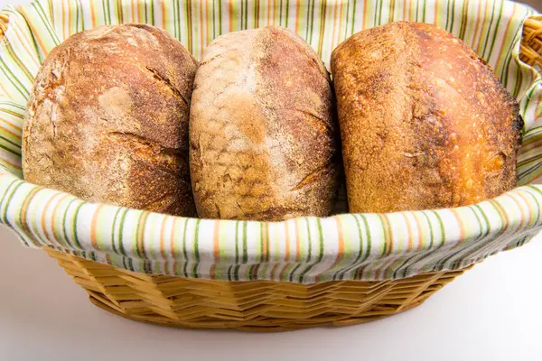 Trzy loafs chleba zakwas w kosz na chleb — Zdjęcie stockowe