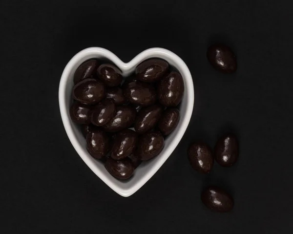 Dark Chocolate Candy Covered Almonds Heart Shaped Bowl Black Background — Stock Photo, Image