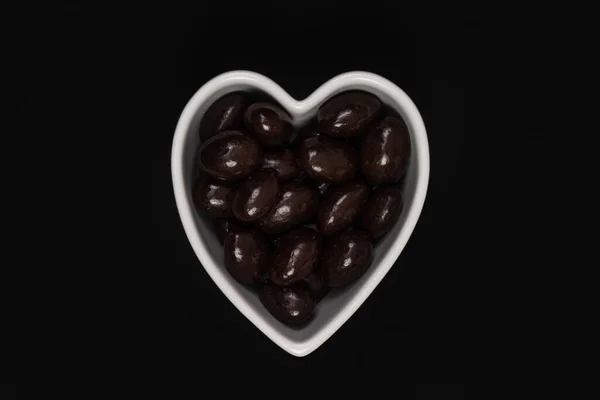 Dark Chocolate Candy Covered Almonds Heart Shaped Bowl Black Background — Stock Photo, Image
