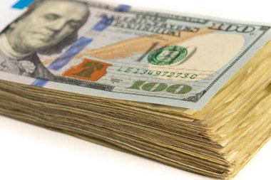 Beyaz arka planda izole edilmiş 100 dolarlık banknot yığını..