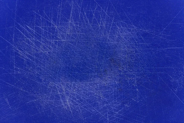 Blue, plastic, grained cutting board with a lot of scratches.