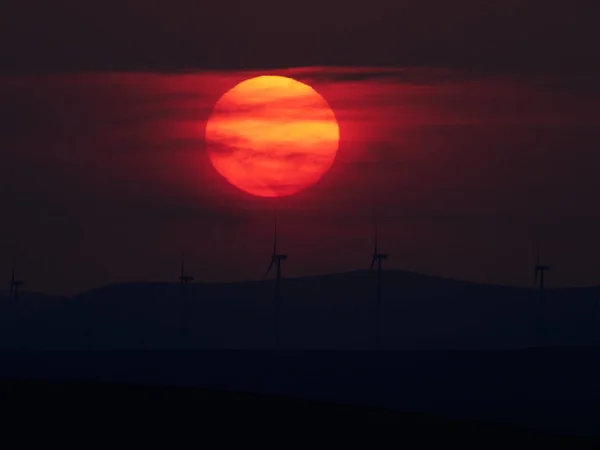 Όμορφο ηλιοβασίλεμα με τις ανεμογεννήτριες στο λόφο — Φωτογραφία Αρχείου