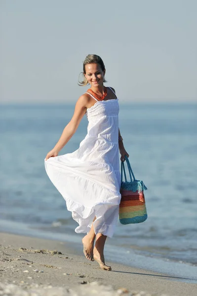 Νεαρή γυναίκα ευτυχισμένη στην παραλία το καλοκαίρι — Φωτογραφία Αρχείου