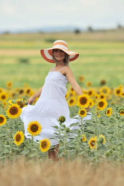 Женщина в цветущем подсолнечном поле летом — стоковое фото