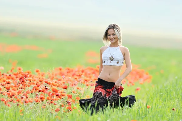 Kvinna i spannmål fält med blommande vallmor — Stockfoto