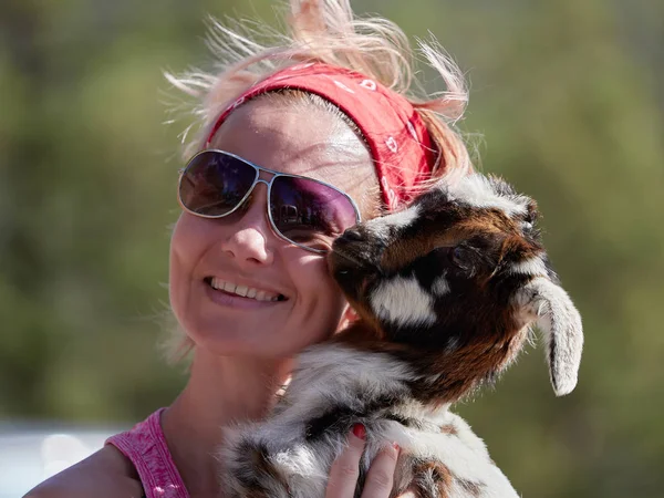 young smiling woman holding goat