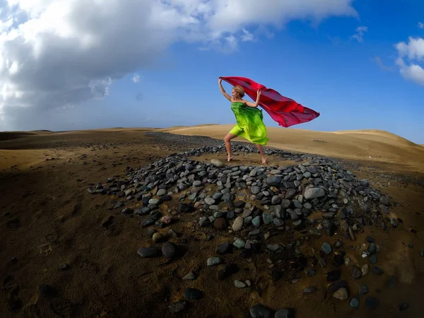 woman dancing on sand dunes in summer