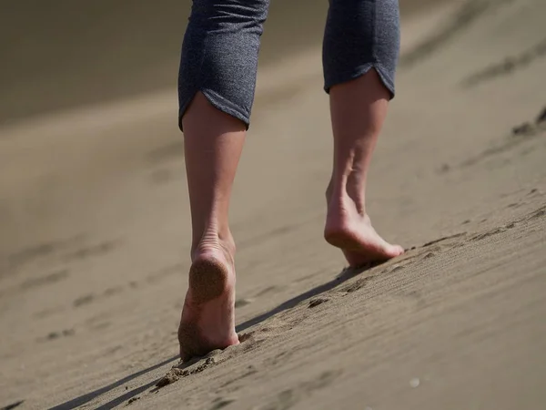 Mulher correndo / andando na praia ao nascer do sol — Fotografia de Stock