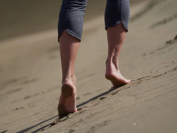 Vrouw joggen/wandelen op het strand bij zonsopgang — Stockfoto