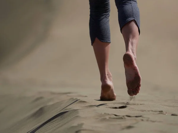 Женщина бег / прогулки по пляжу на рассвете — стоковое фото
