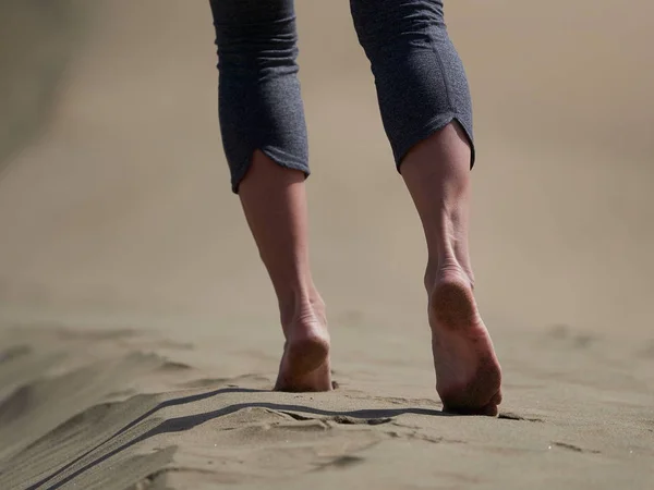 Žena kondiční běh/chůze na pláži při západu slunce — Stock fotografie