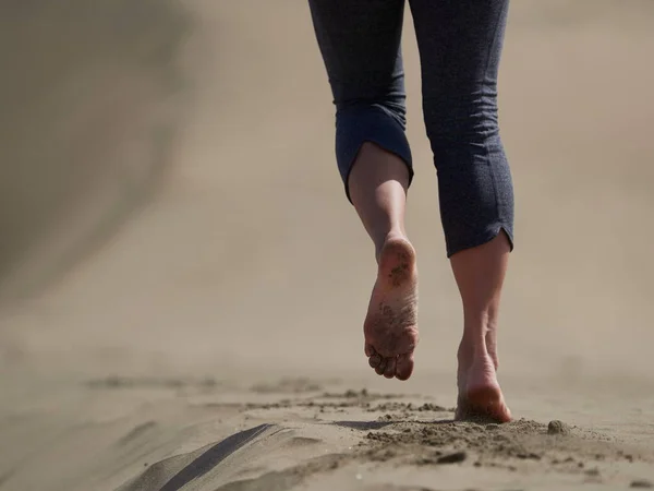 Frau joggt / geht bei Sonnenaufgang am Strand — Stockfoto