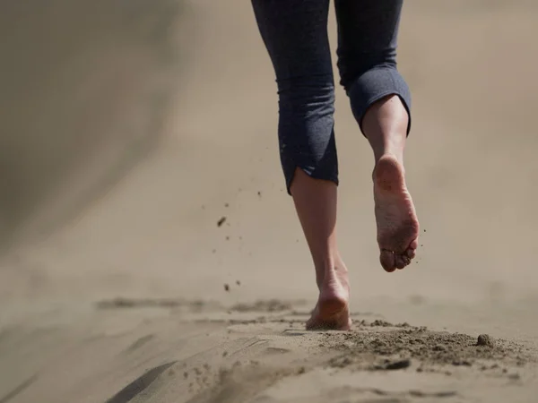 Vrouw joggen/wandelen op het strand bij zonsopgang — Stockfoto