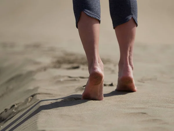 Mulher correndo / andando na praia ao nascer do sol — Fotografia de Stock