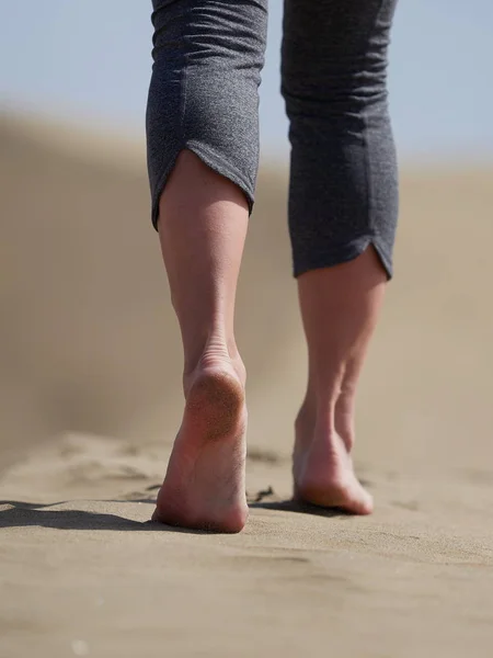 Kvinna jogging/promenad på stranden i soluppgången — Stockfoto