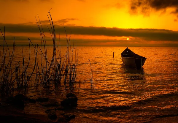 Pôr do sol sobre a água e silhueta do barco de pesca — Fotografia de Stock