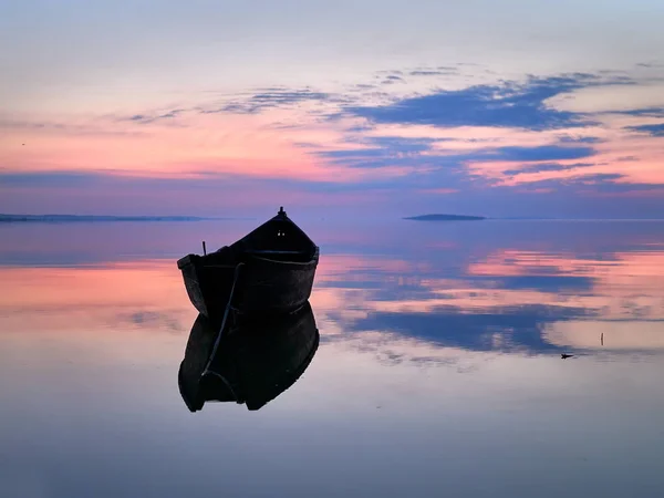 Схід сонця над водою і силует рибальського човна — стокове фото