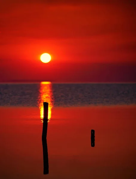 Zachód słońca nad wodą i sylwetka łodzi rybackiej — Zdjęcie stockowe