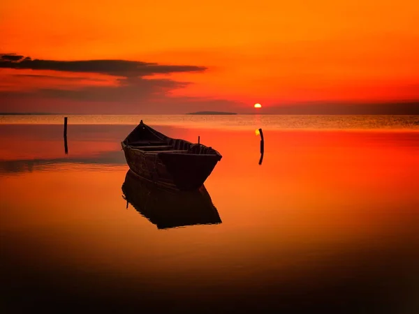 Pôr do sol sobre a água e silhueta do barco de pesca — Fotografia de Stock