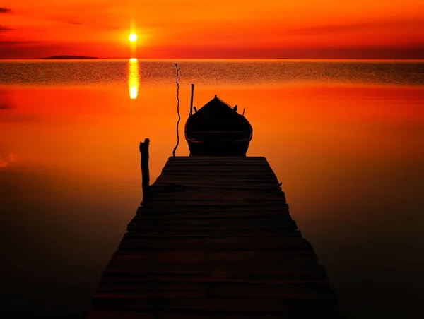 Sonnenuntergang über dem Wasser und Silhouette eines Fischerbootes — Stockfoto