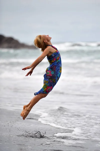 Genç bir kadın plajda atlıyor. — Stok fotoğraf
