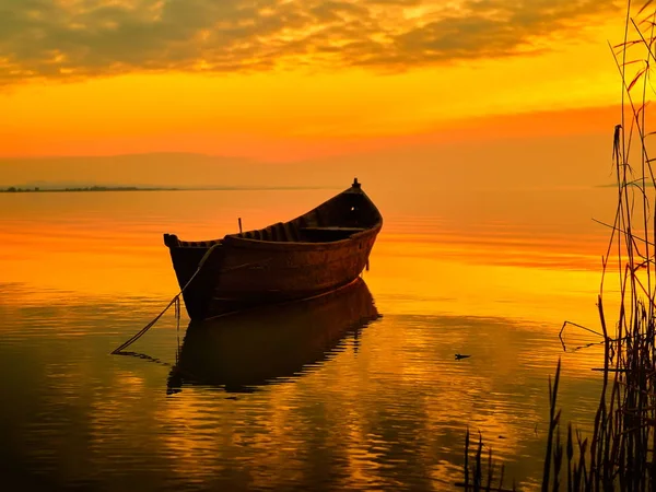Solnedgång över vatten och silhuetten av fiskebåt — Stockfoto