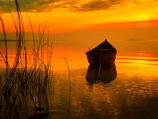 Puesta de sol sobre el agua y silueta del barco pesquero — Foto de Stock