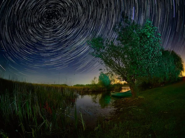 Céu bonito à noite com trilhas estelares sobre o lago — Fotografia de Stock