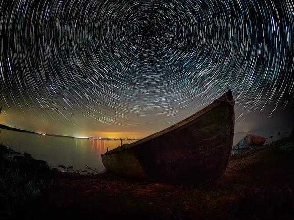 Obloha v noci s startrails nad jezerem — Stock fotografie