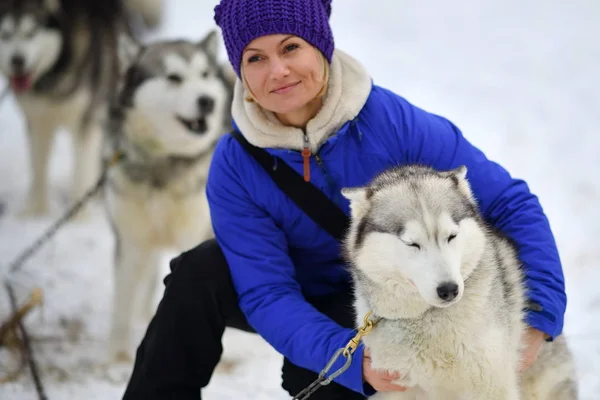 Lächelnde Frau umarmt Husky-Hund — Stockfoto
