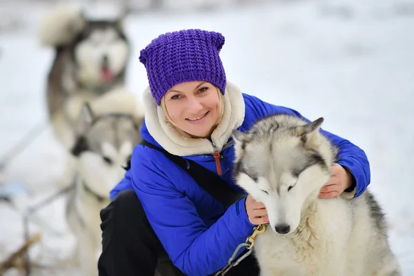 Lachende vrouw knuffelen husky hond — Stockfoto