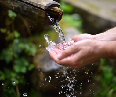 yıkama adam taze, soğuk, dağ spri içme suyu eller.