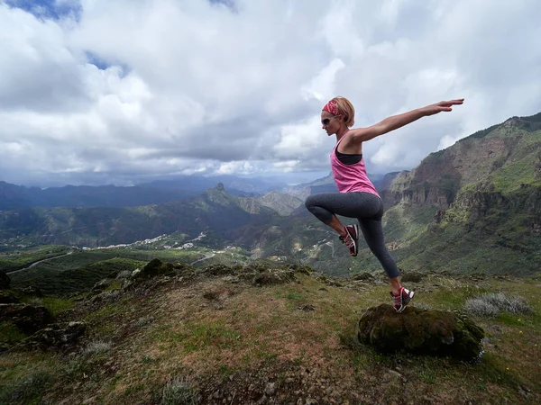 Mujer saltando en la cima de la montaña —  Fotos de Stock