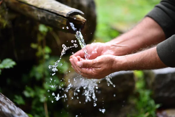 Homem lavando as mãos em fresco, frio, água potável de montanha spri — Fotografia de Stock