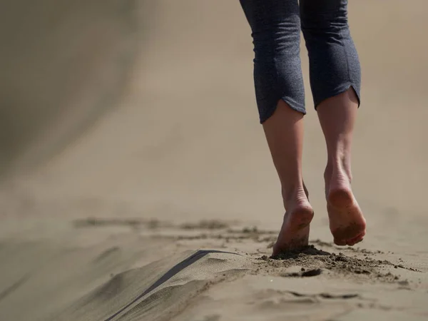 Pieds nus de jeune femme jogging / marche sur la plage au lever du soleil — Photo