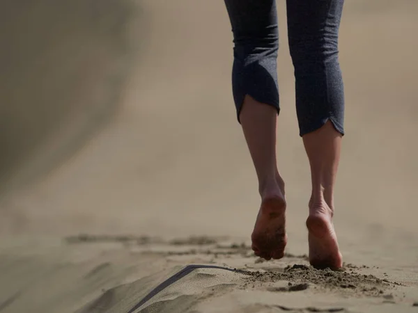 Bara fötter av ung kvinna jogging/promenad på stranden i soluppgången — Stockfoto