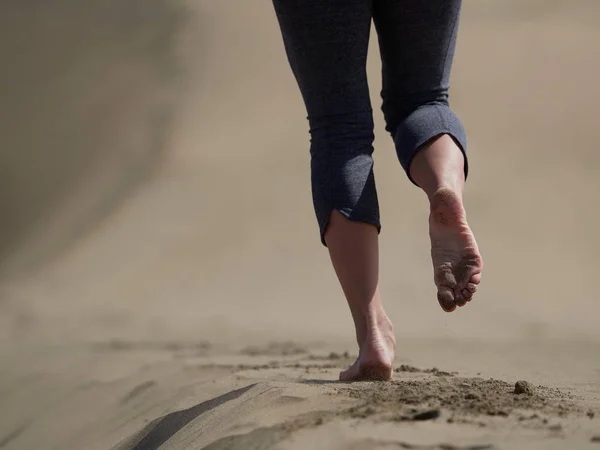 年轻女子跑步/步行在日出海滩上赤裸的双脚 — 图库照片