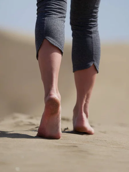 Pés descalços de mulher jovem correndo / andando na praia ao nascer do sol — Fotografia de Stock