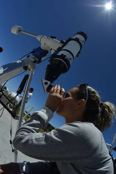 Kobieta szuka przez teleskop — Zdjęcie stockowe