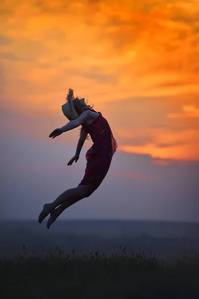 Gelukkige vrouw op veld in zomer zonsondergang — Stockfoto