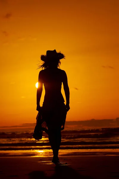 Jonge vrouw silhouet op het strand — Stockfoto