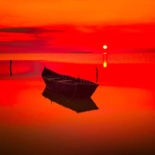 Sunset over water and silhouette fishing boat — Stock Photo, Image