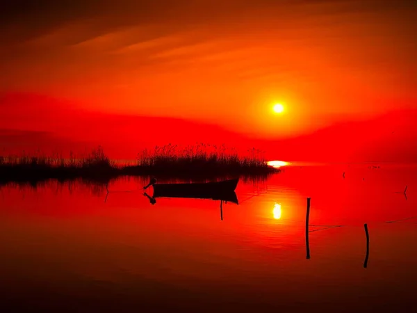 Pôr do sol sobre a água e silhueta barco de pesca — Fotografia de Stock