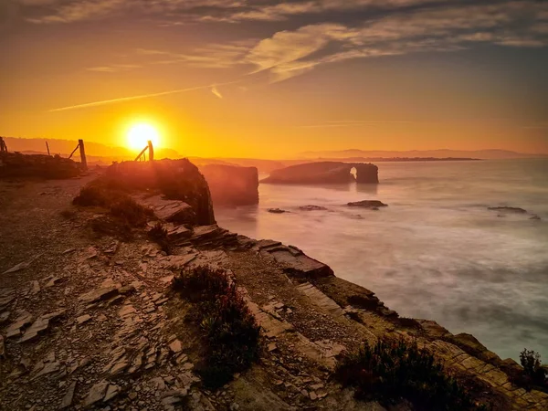 Wunderschöner Sonnenuntergang und Steinbögen auf der playa de las catedrales dur — Stockfoto